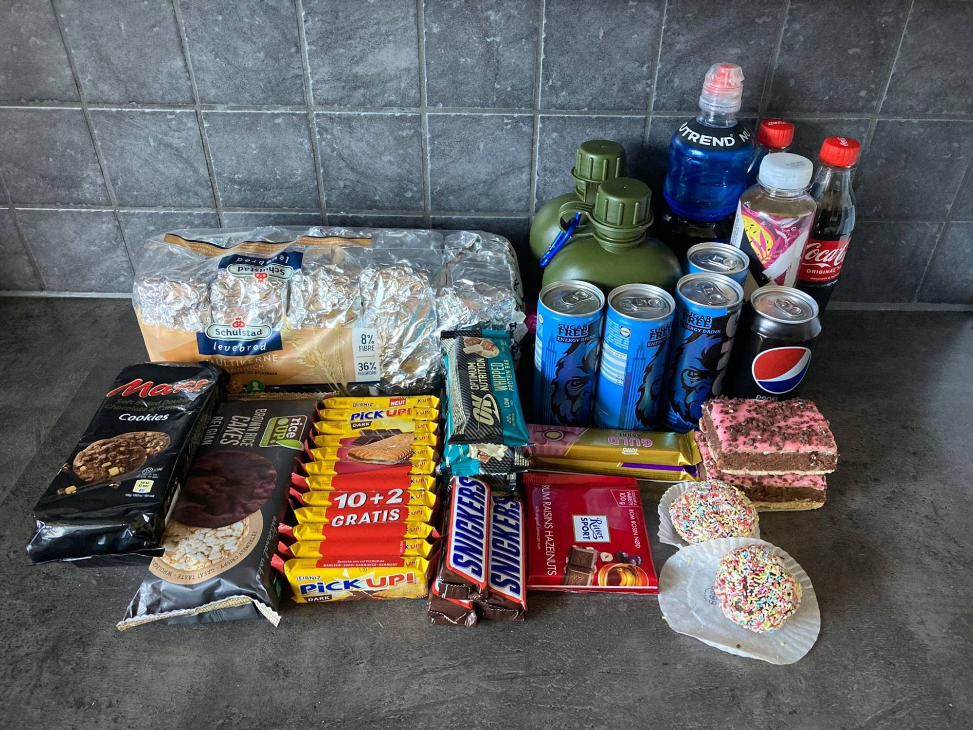 Food and drink for the walk: sandwiches in foil, chocolate bars, biscuits, cakes, energy drinks, cola and two water bottles