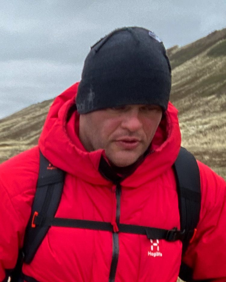 Close-up of a tired face in a beanie and red jacket