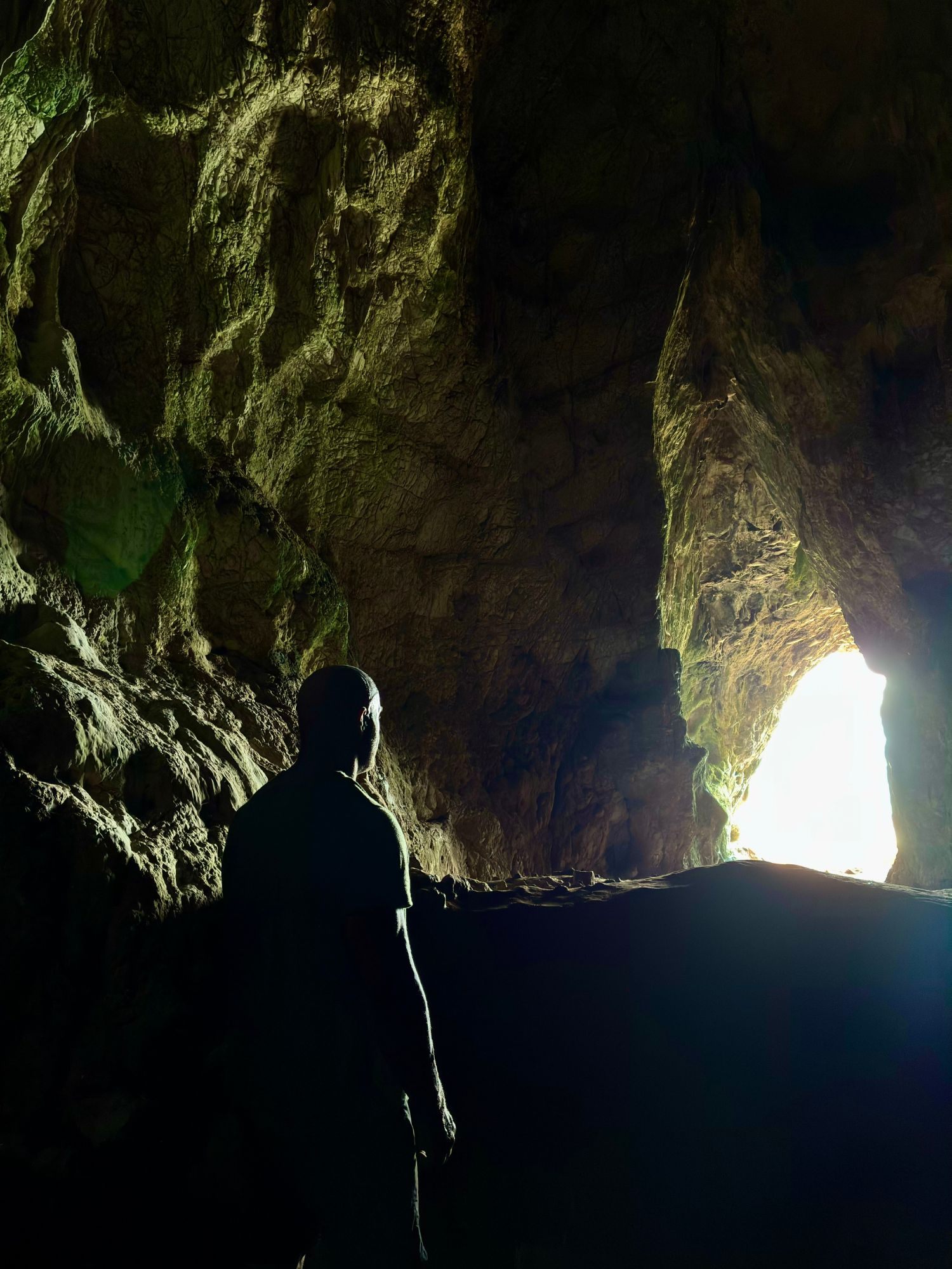 Silhouette inside Nestor's Cave, looking towards the bright opening in the rock