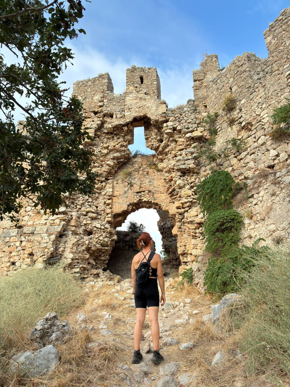Kristine standing before the crumbling gateway and battlements of Old Navarino Castle