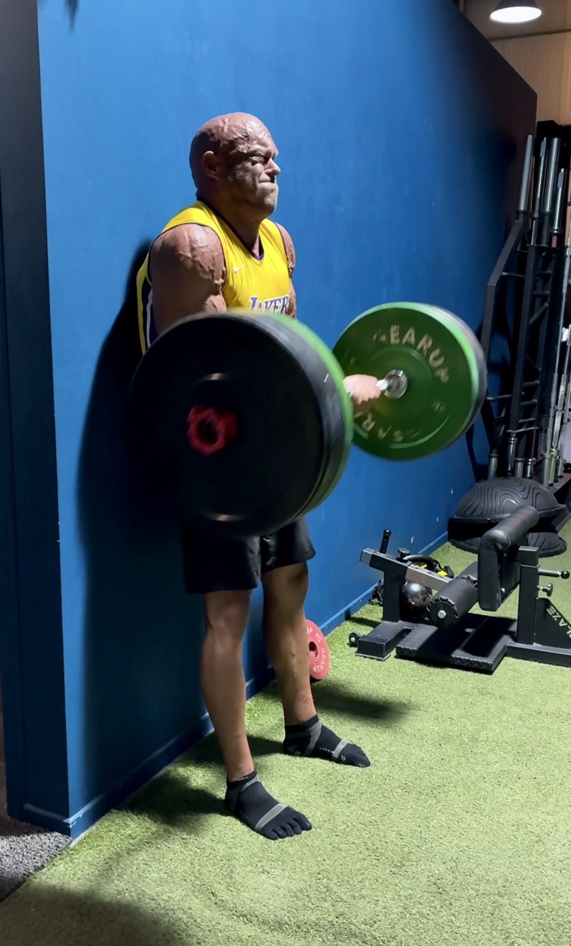 Lifting a loaded barbell against the wall at a gym in Pylos