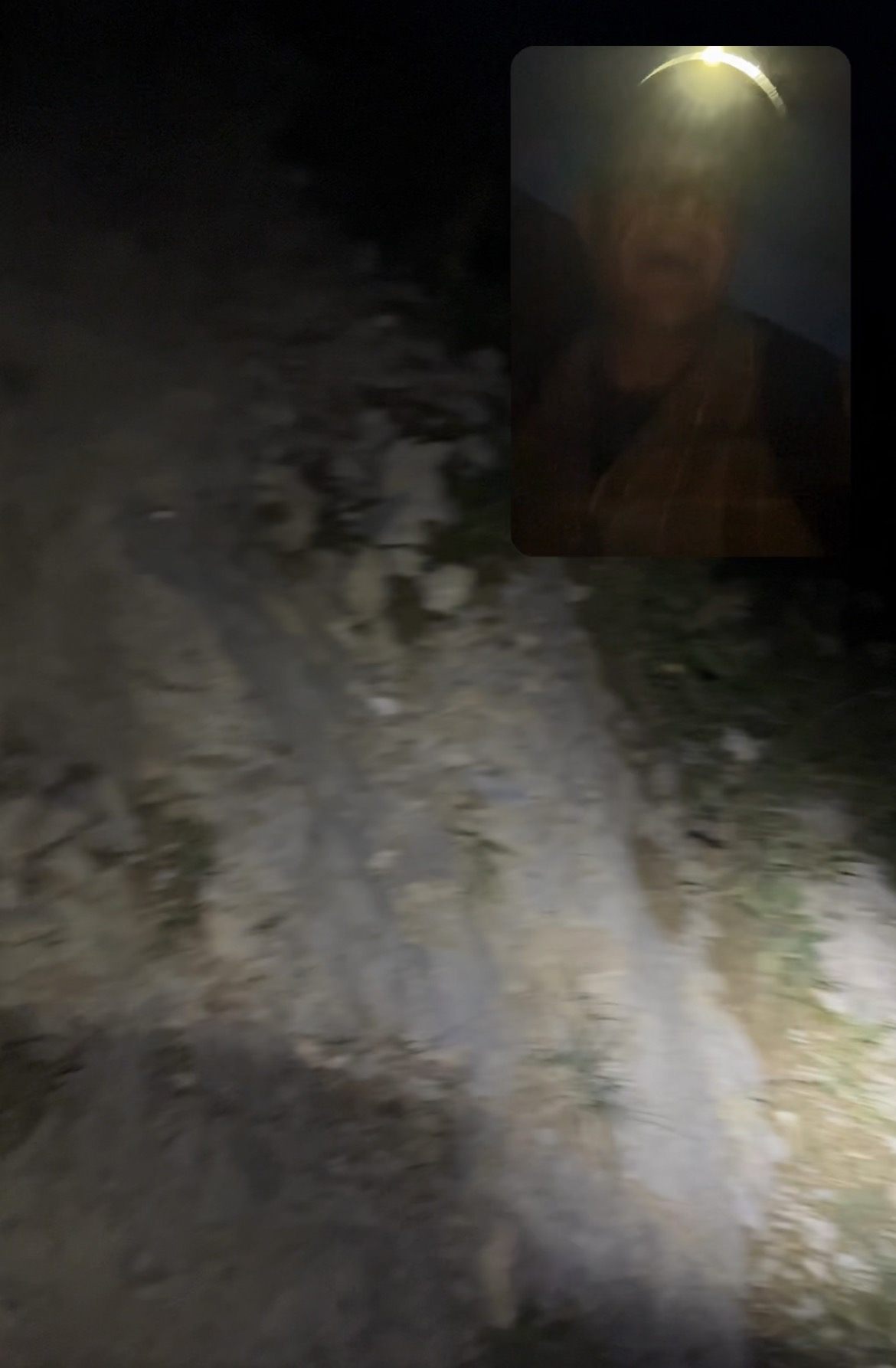 The trail lit up by a head torch in the dark, with a small selfie inset of the hiker wearing the head torch