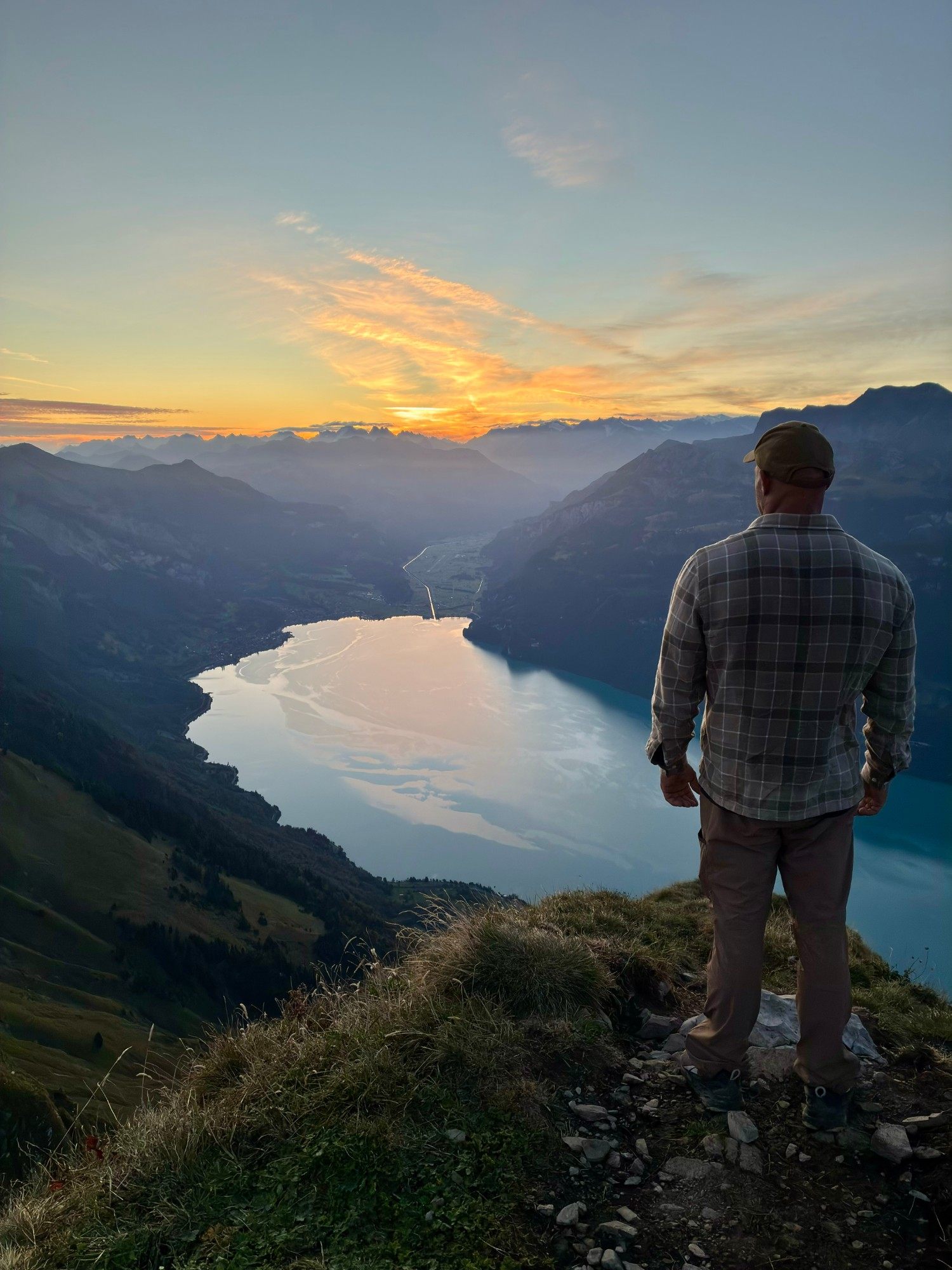 Standing on the edge of the ridge looking down over the turquoise Lake Brienz at dawn