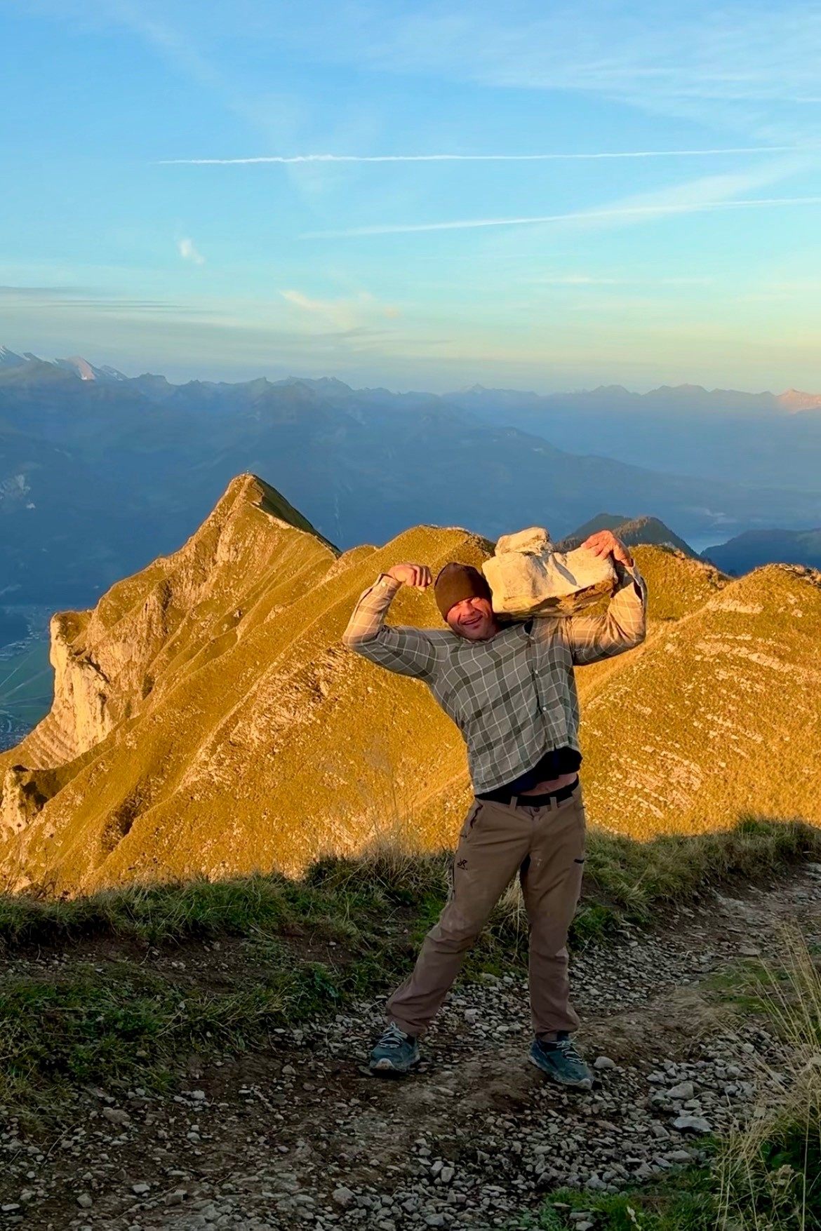 The same rock and pose on the ridge, now lit up golden by the morning sun