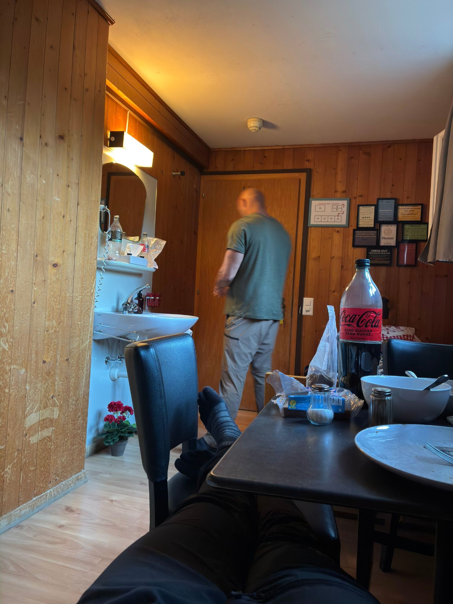 Our small wood-panelled room at the Horner in Lauterbrunnen, with a sink, a small table and chairs