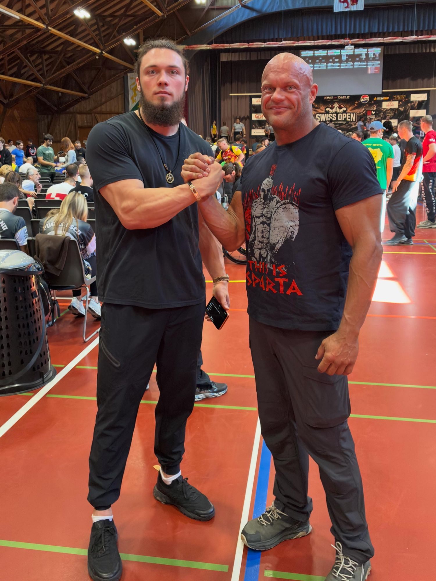 Leif and Oleksandr Manifestor Telyatnik clasping hands inside the Swiss Open hall