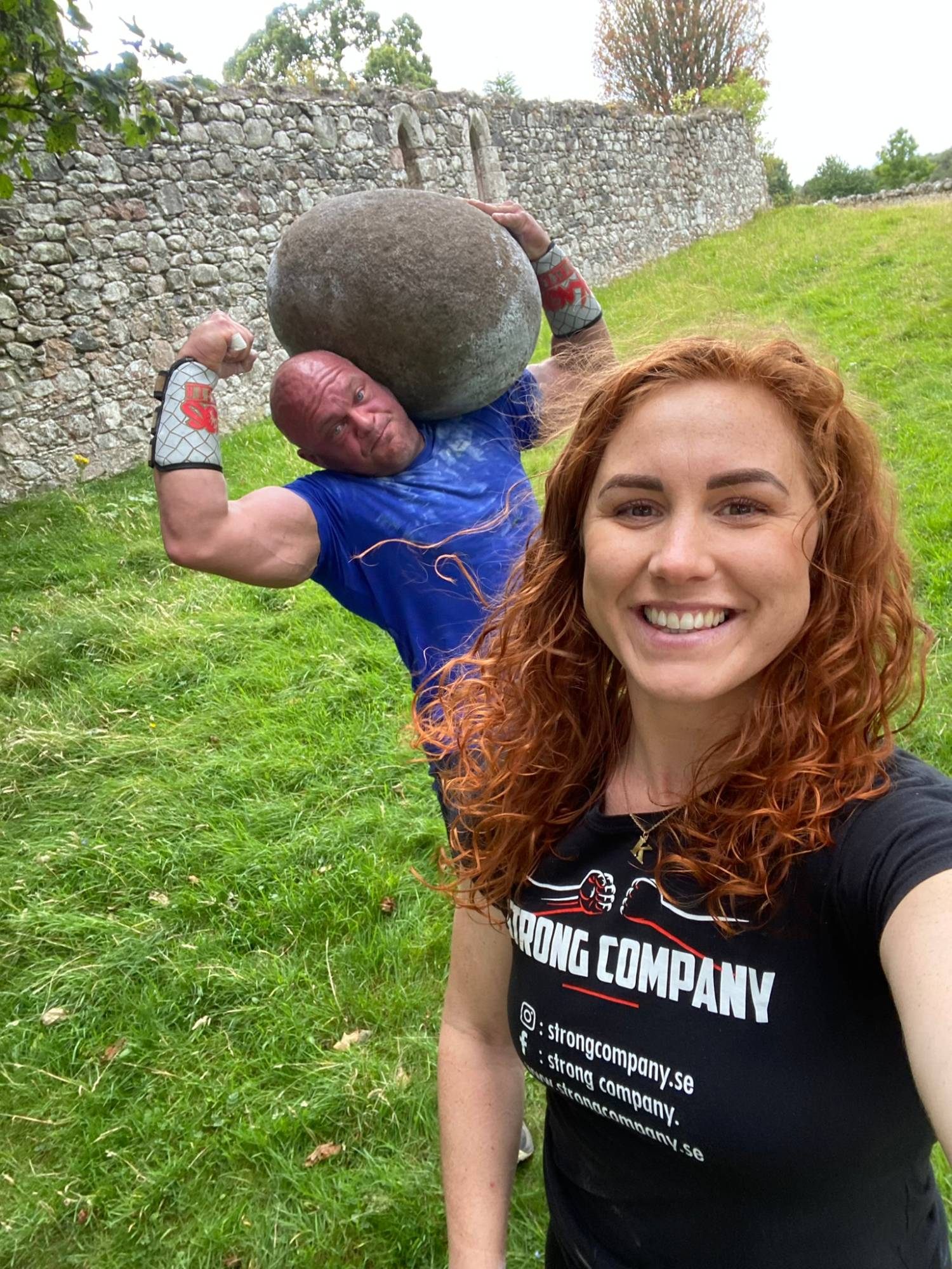 Kristine smiling in a selfie while Leif holds the Barevan Stone on his shoulder behind her