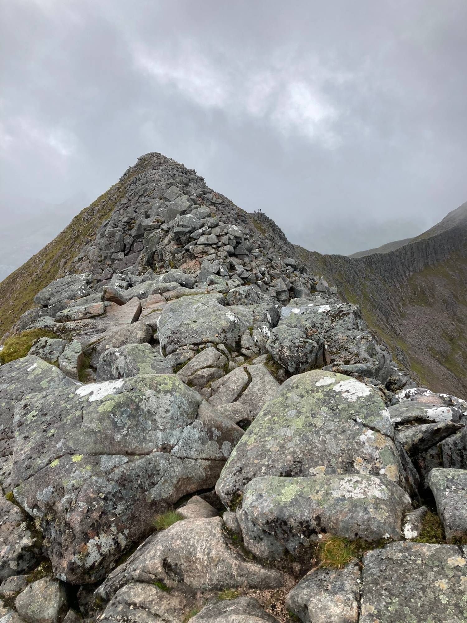 The rocky crest of the CMD Arête rising towards a peak, with tiny figures of other hikers on the ridge