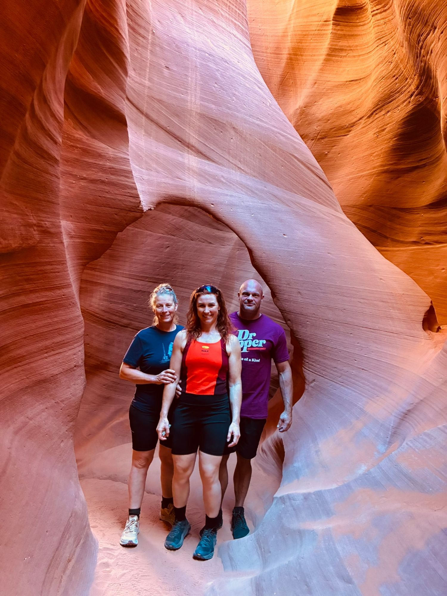 Inge, Kristine and Leif standing under a sandstone arch inside Lower Antelope Canyon