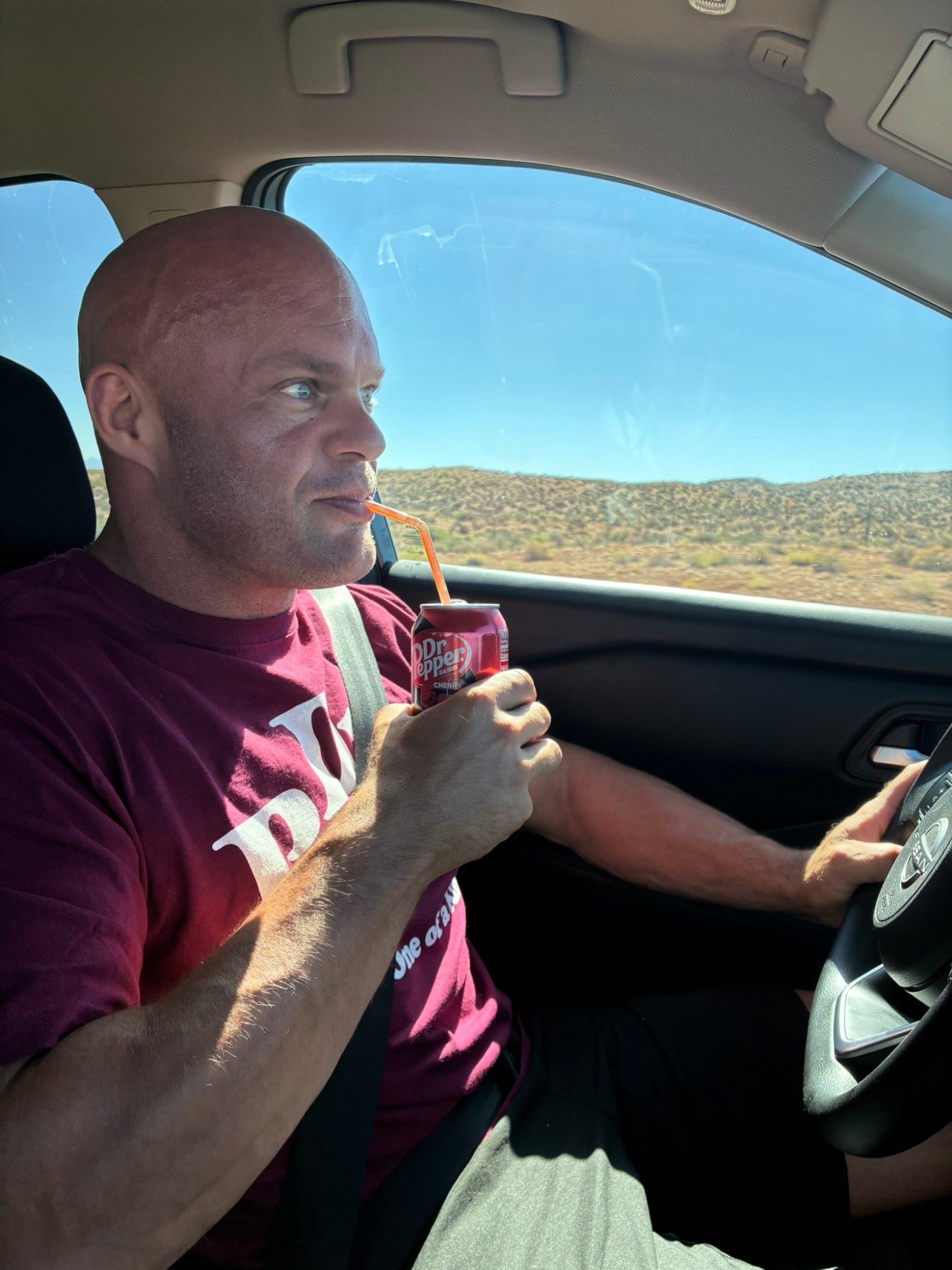 Leif driving through the Arizona desert, sipping a Cherry Dr Pepper through a straw
