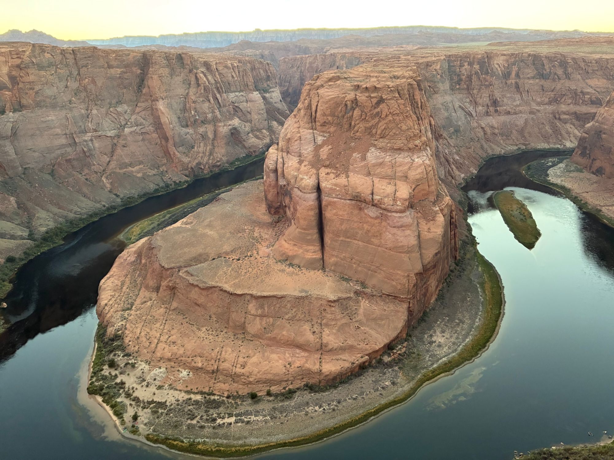 The Colorado River looping around the huge sandstone formation at Horseshoe Bend in soft evening light