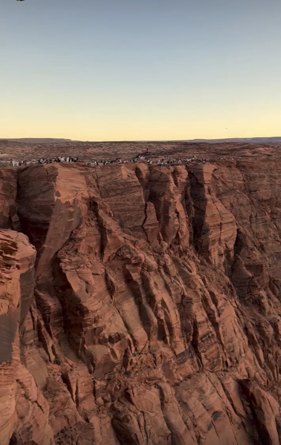 Crowds lined up along the canyon rim at the main Horseshoe Bend overlook in the evening
