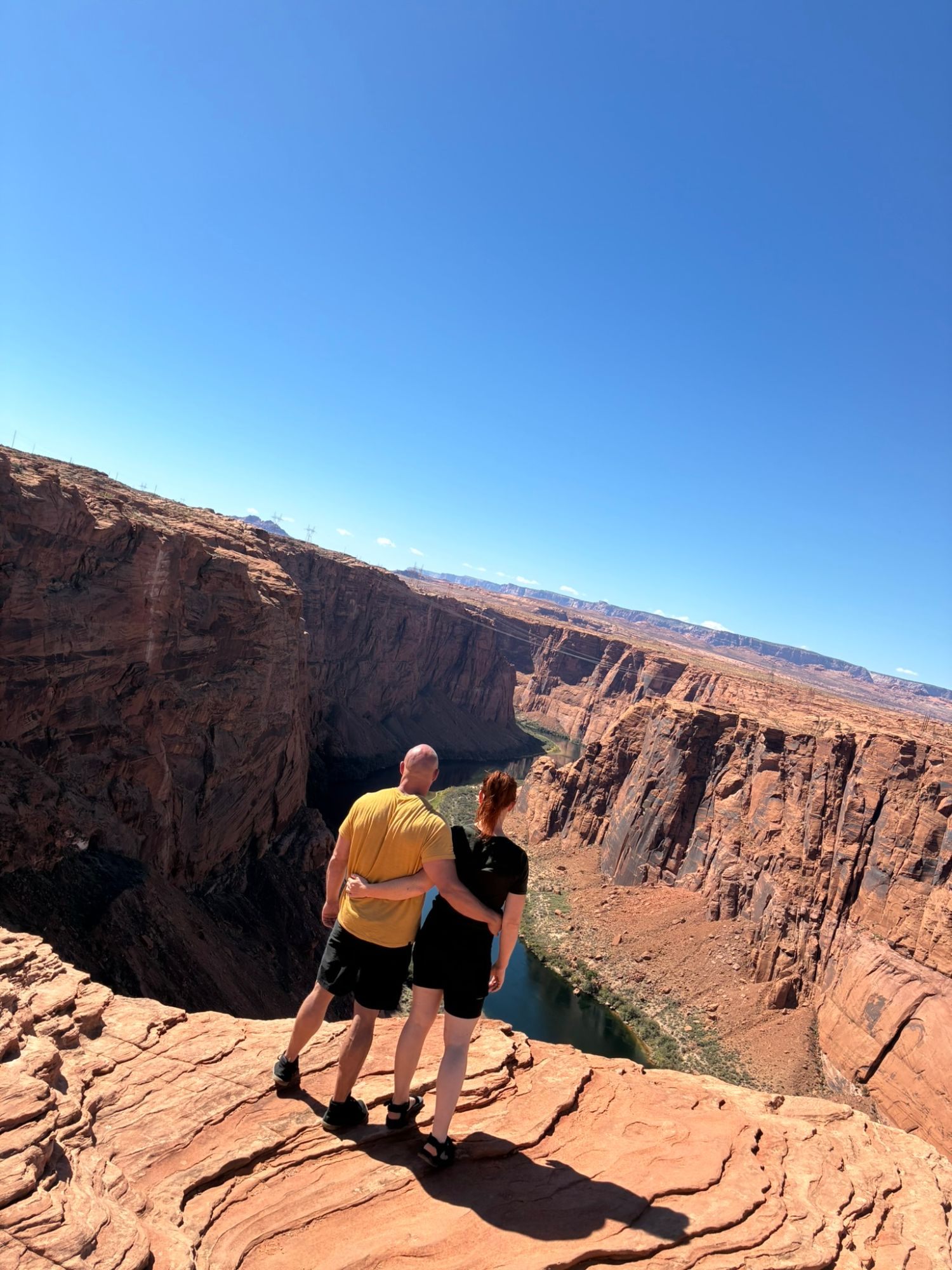 Leif and Kristine looking out over Glen Canyon and the Colorado River under a deep blue sky