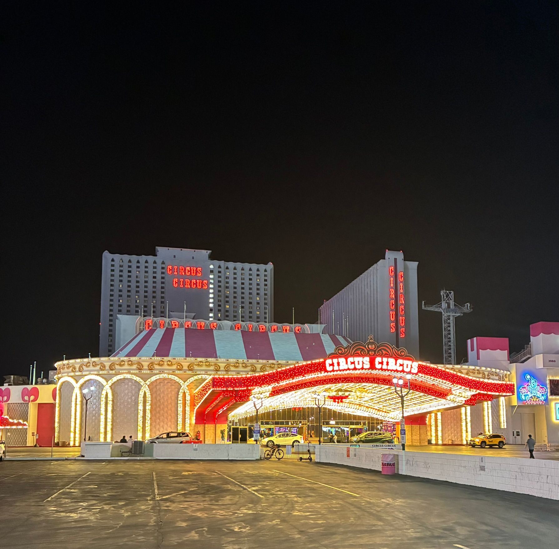 Circus Circus at night with its striped big-top roof, lit arches and two hotel towers
