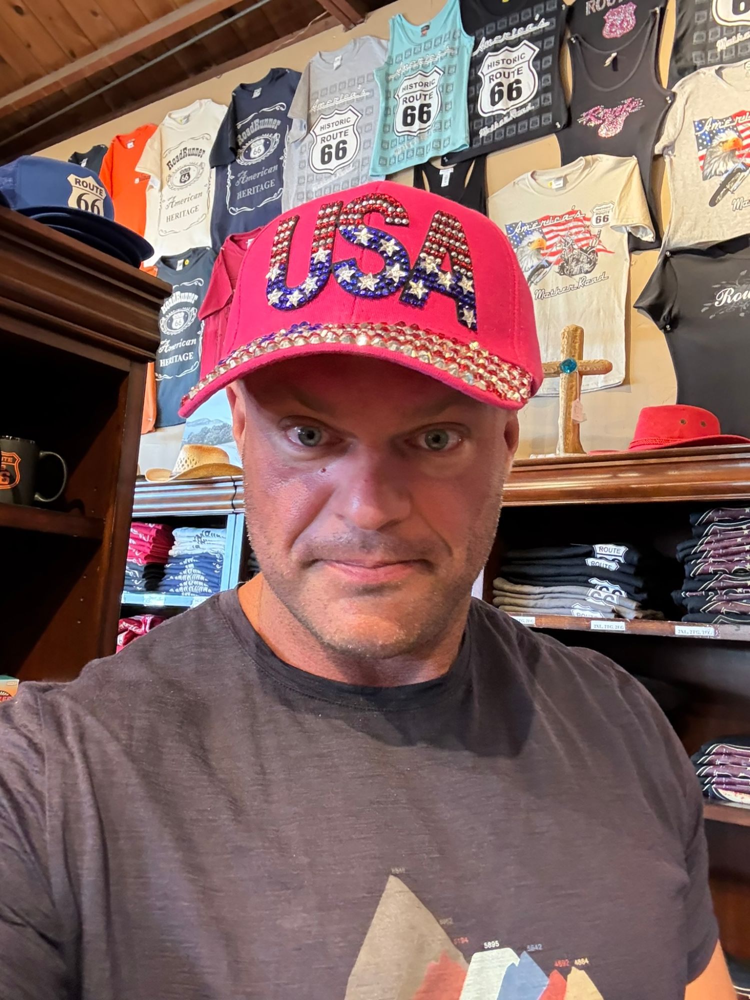 Leif in a sparkly pink USA cap in a souvenir shop full of Route 66 T-shirts