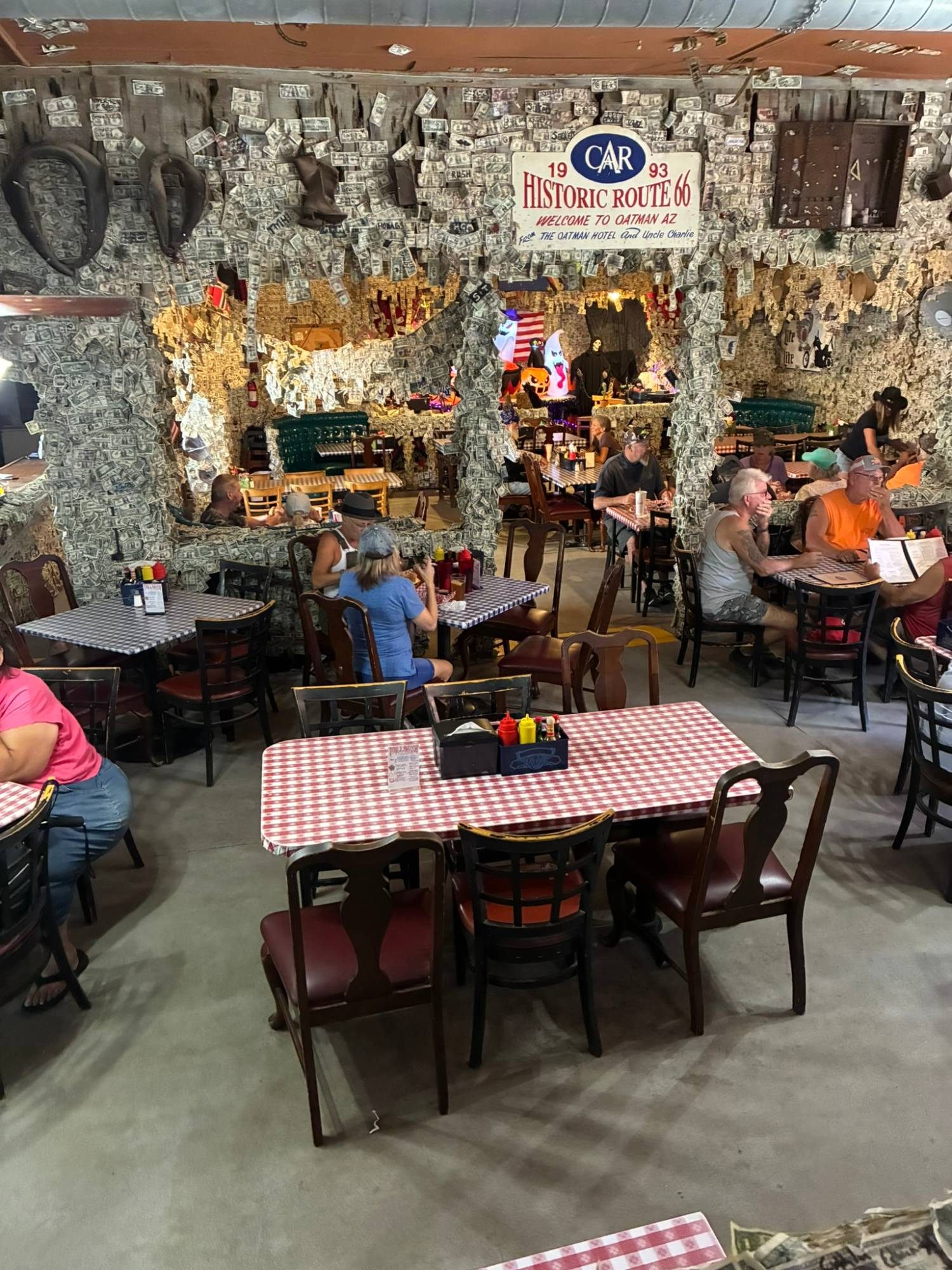 The Oatman Hotel restaurant seen from above, with walls and pillars completely covered in dollar bills