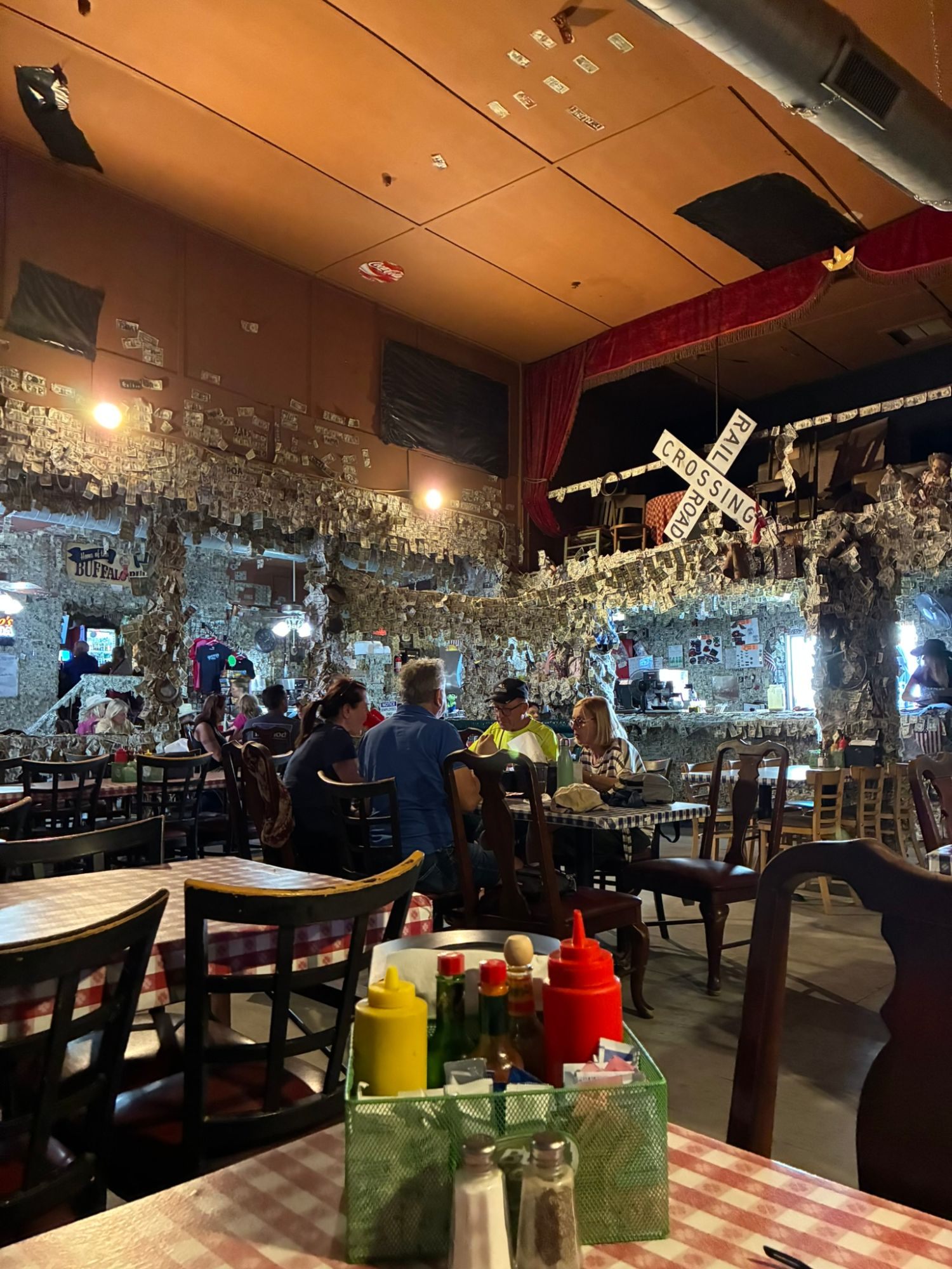 The Oatman Hotel dining room with a railroad crossing sign and walls papered in dollar bills