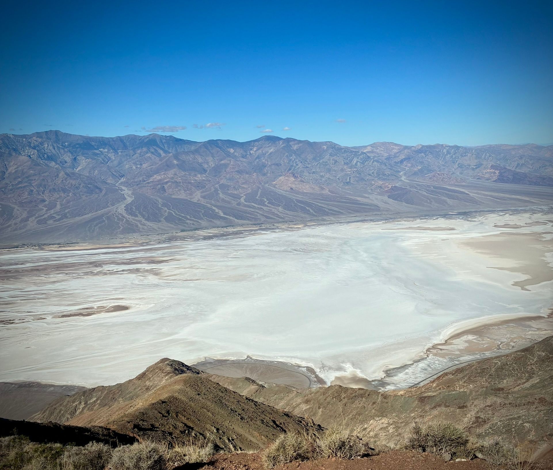 View from Dante's View down onto the white salt flats of Badwater Basin with mountains across the valley
