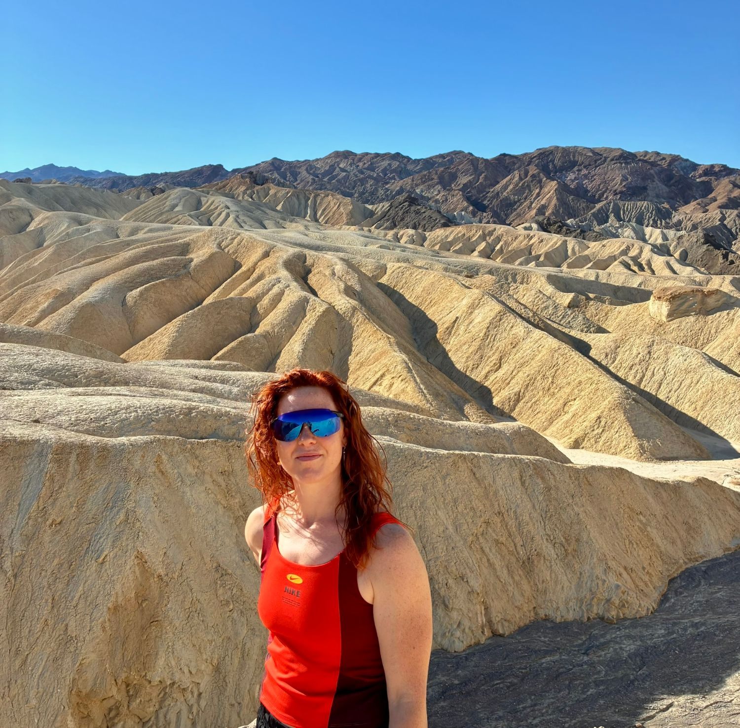 Kristine in sunglasses in front of the ridged badlands at Zabriskie Point