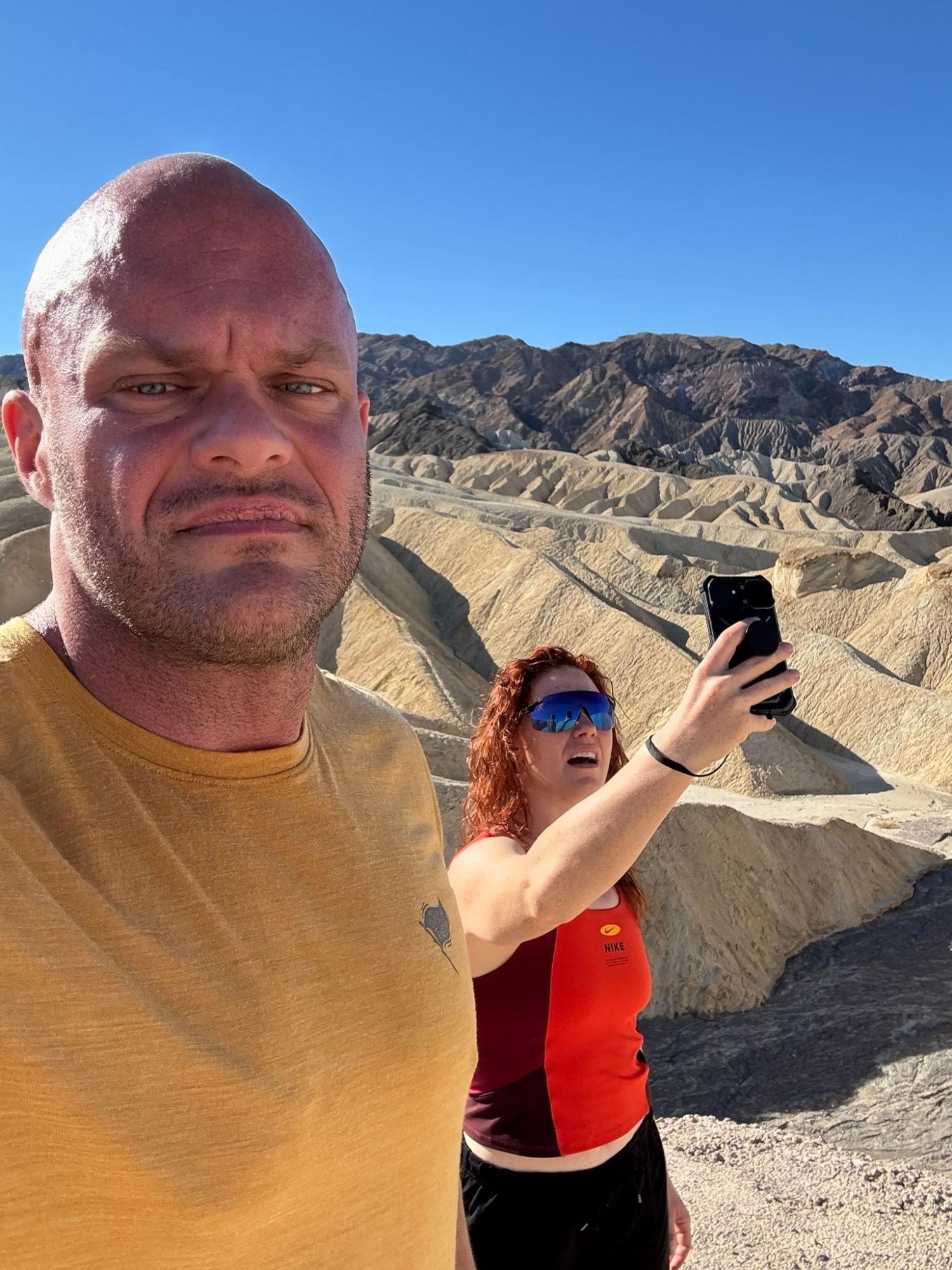 A squinting selfie at Zabriskie Point while Kristine takes a photo behind