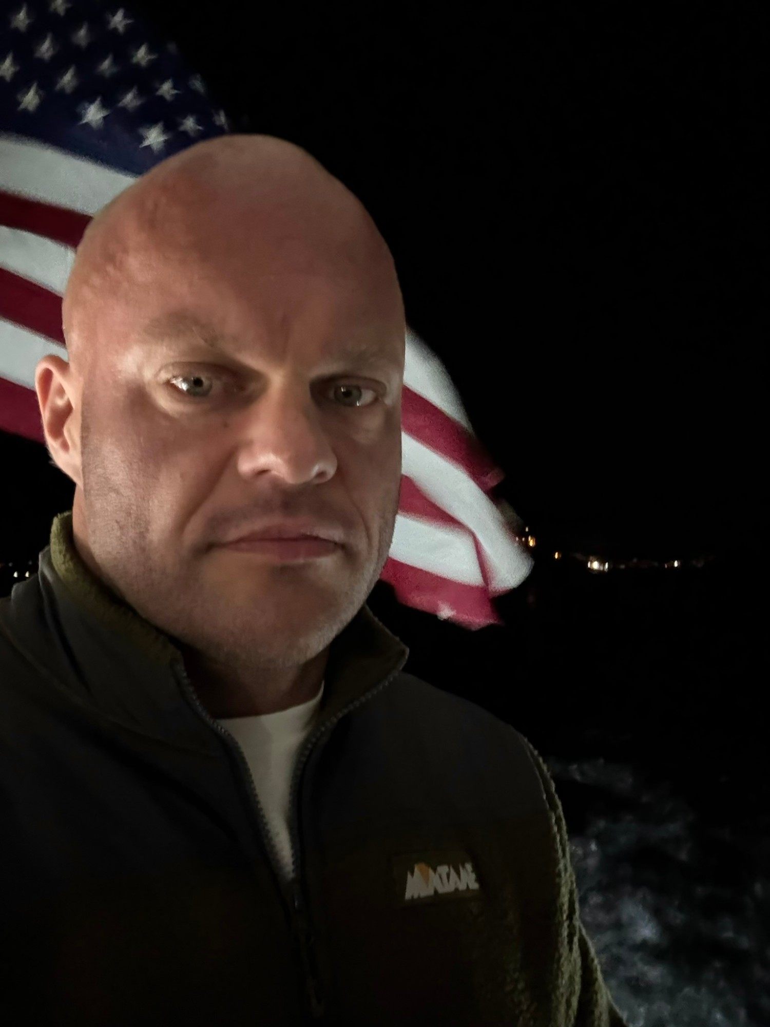 Night selfie on the ferry deck with the American flag blowing behind