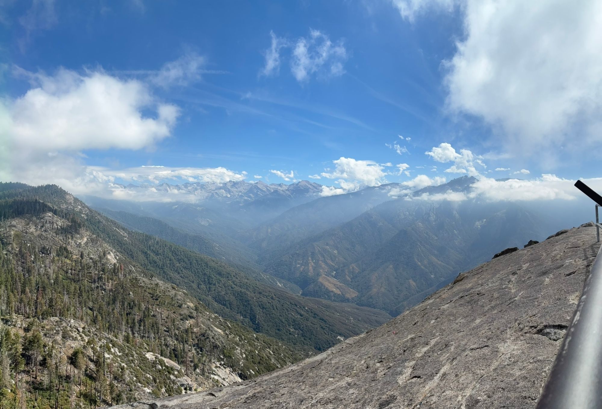 Panorama from the top of Moro Rock over a deep forested valley towards the jagged high peaks of the Sierra Nevada