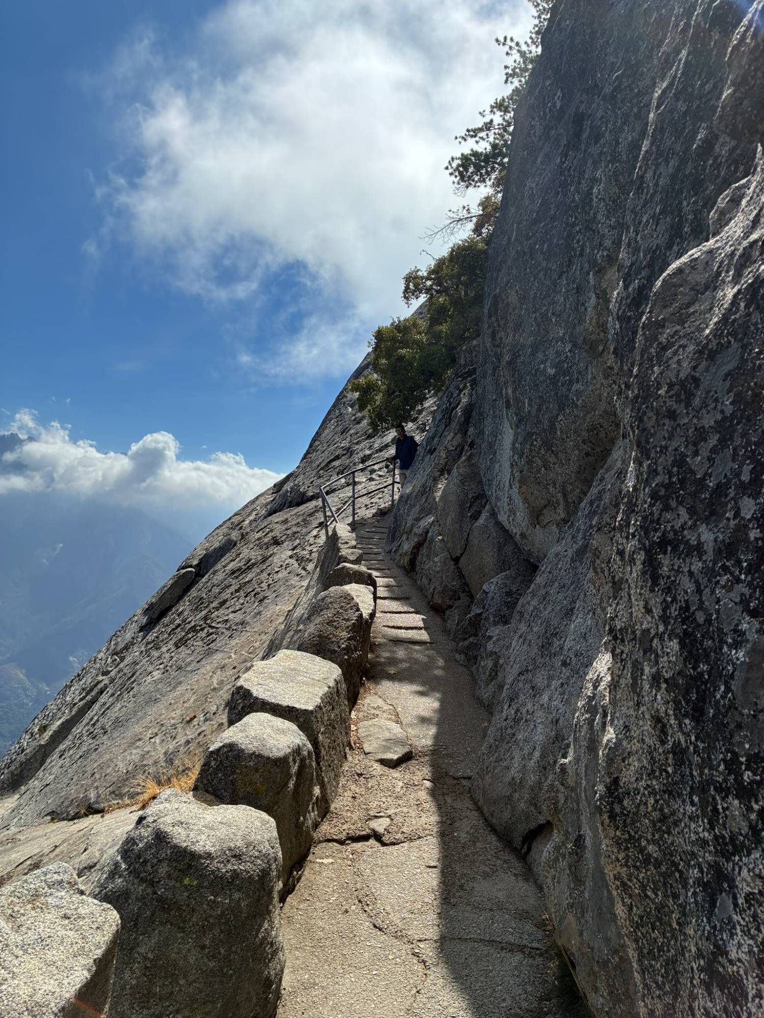 The narrow stone-edged stairway cut into the side of Moro Rock, with a sheer granite wall on one side and the valley far below