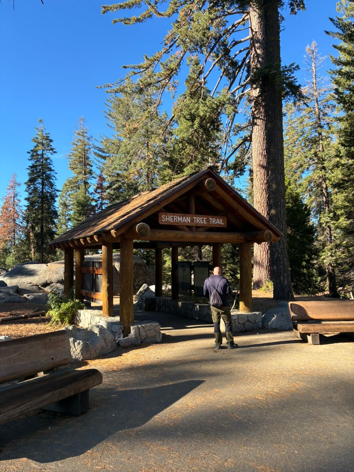 The wooden shelter with the Sherman Tree Trail sign at the start of the trail from the parking area