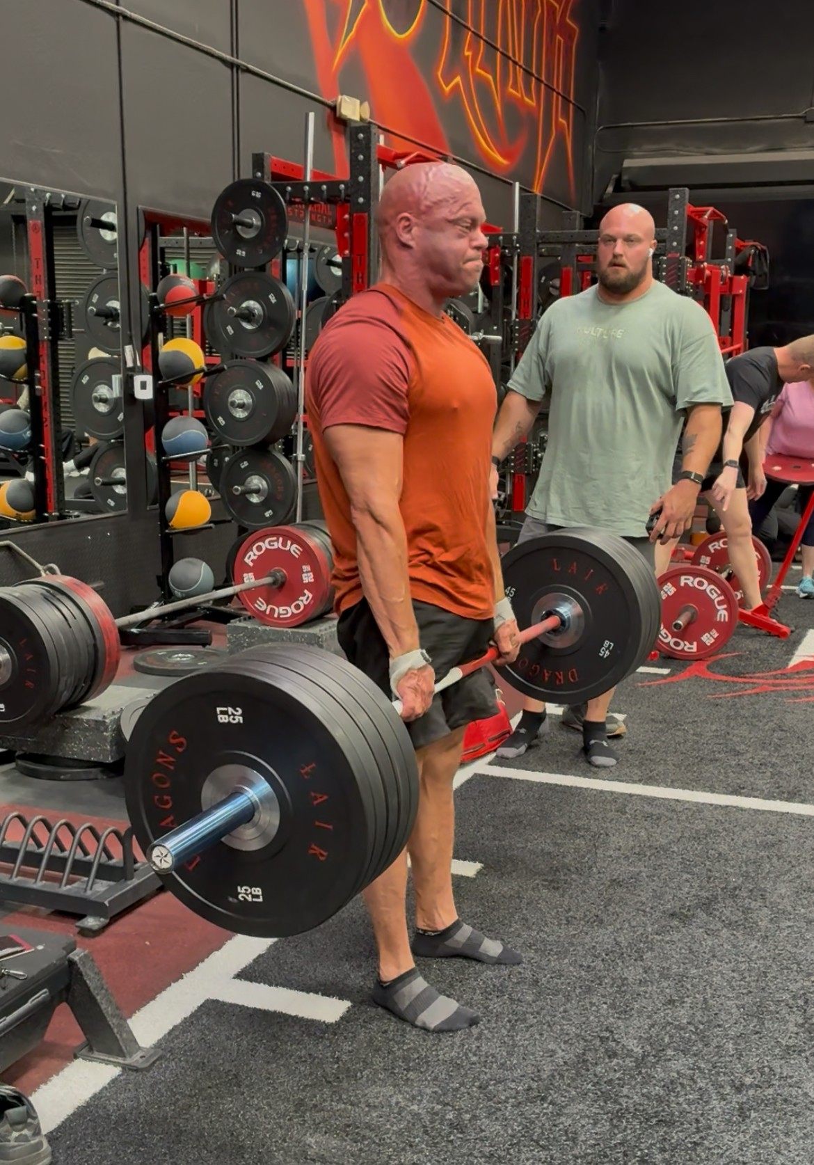 Leif locking out a deadlift in socks while Mitchell Hooper watches