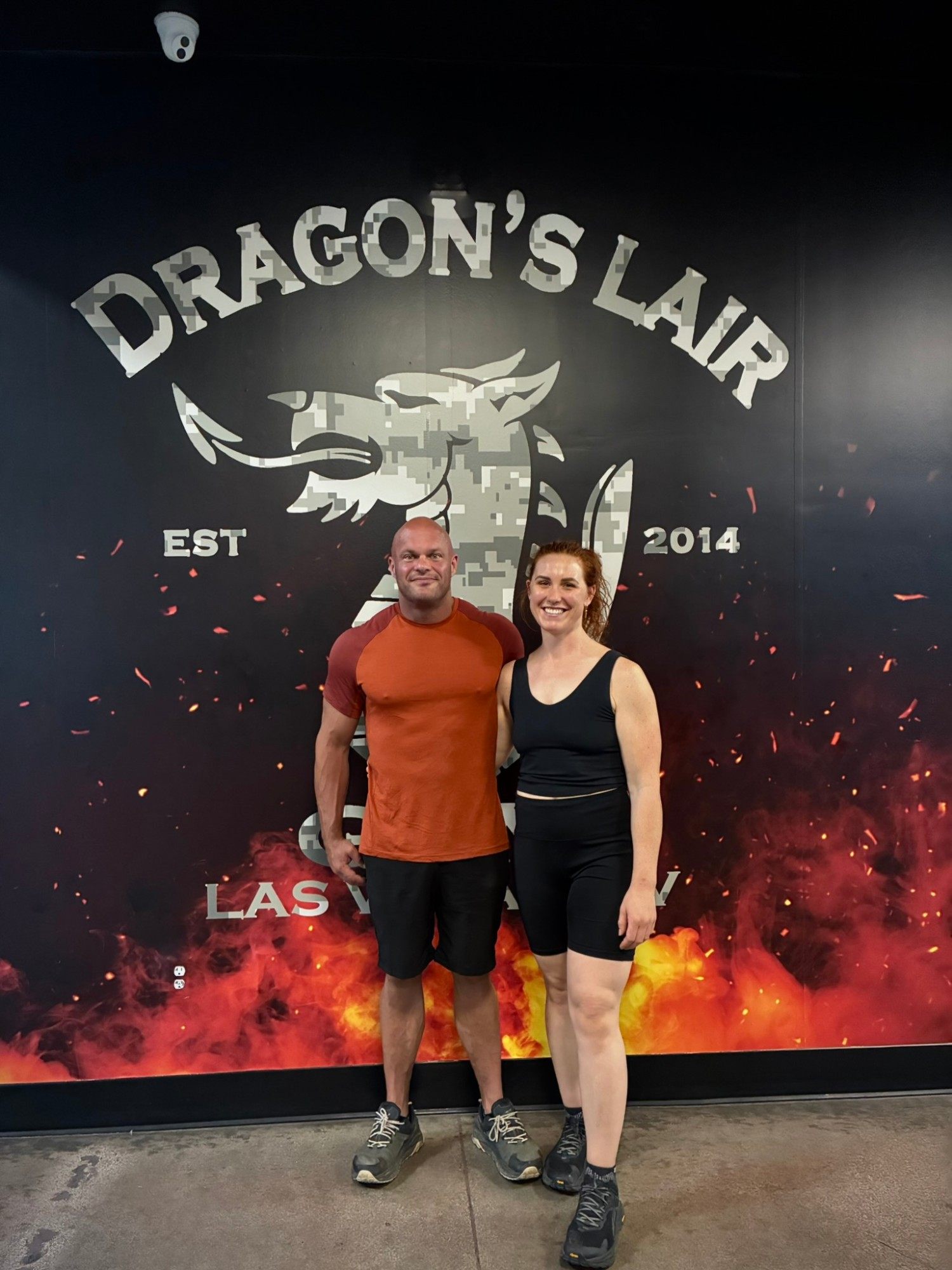 Leif and Kristine in front of a camouflage Dragon's Lair Est 2014 Las Vegas mural